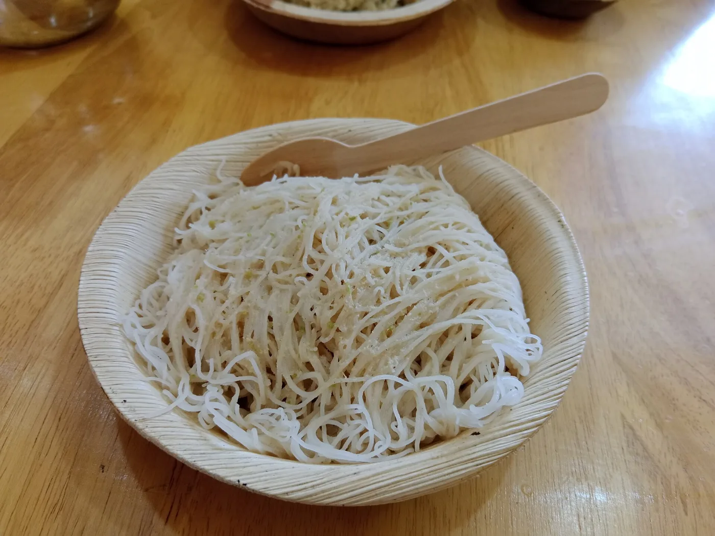 Idiyappam with grated coconut, served in an areca-leaf bowl.