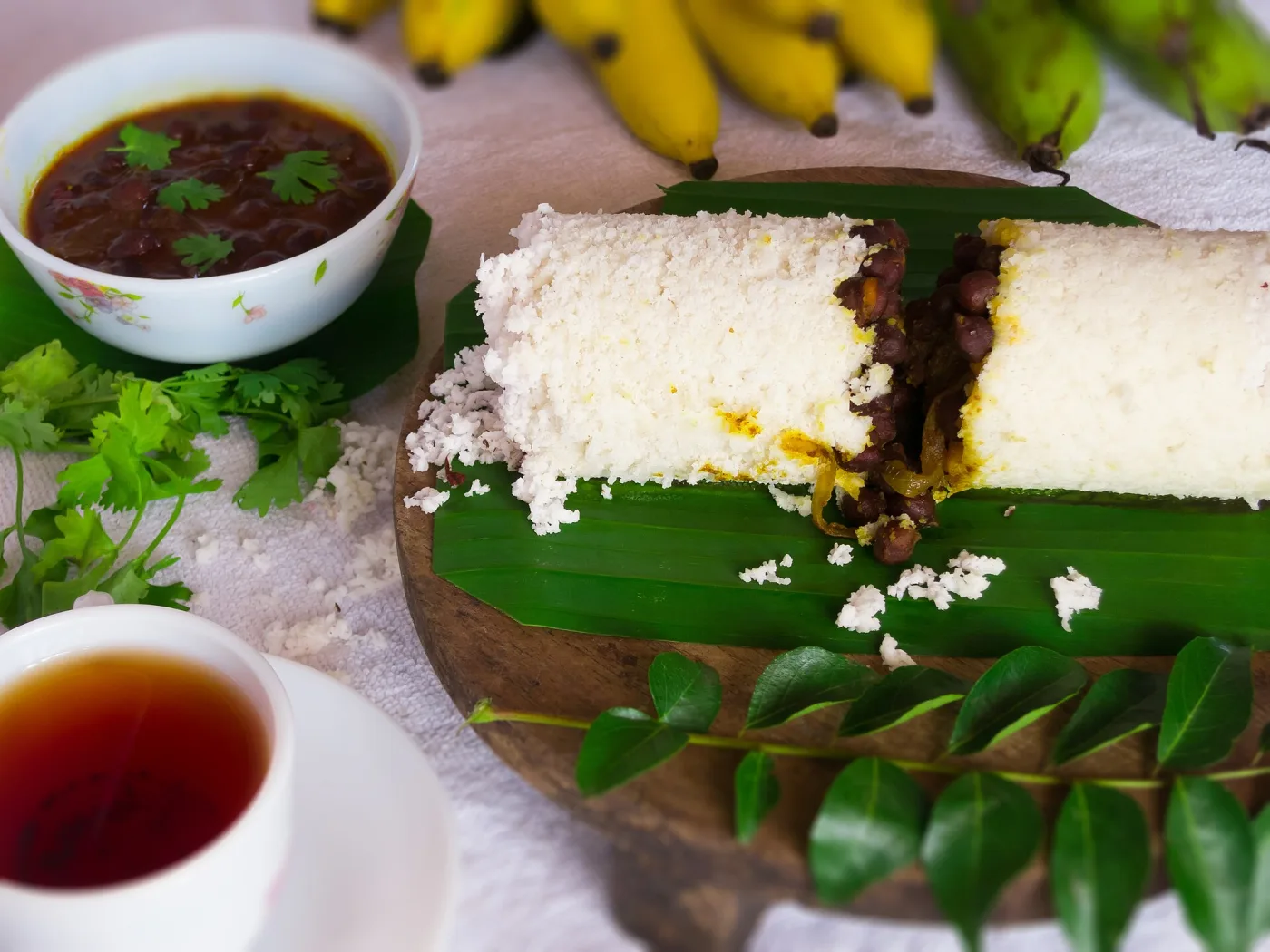 Rice puttu broken over kadala curry, with bananas and black tea.